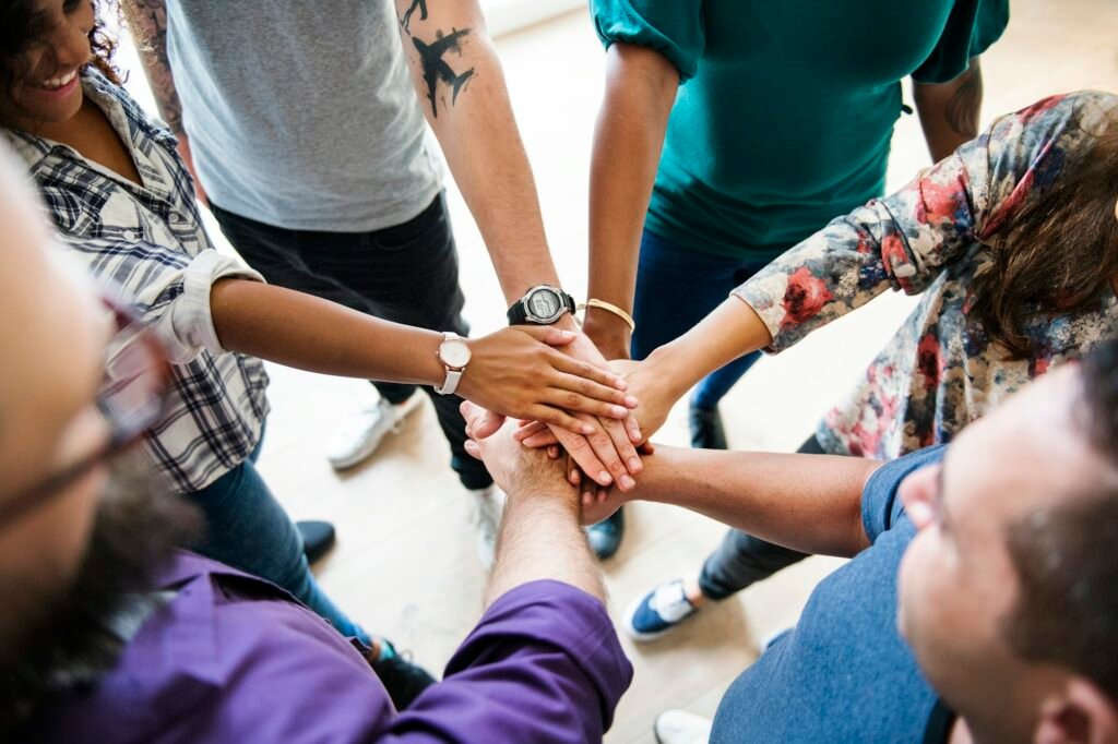 Group of diverse people joined hands together teamwork